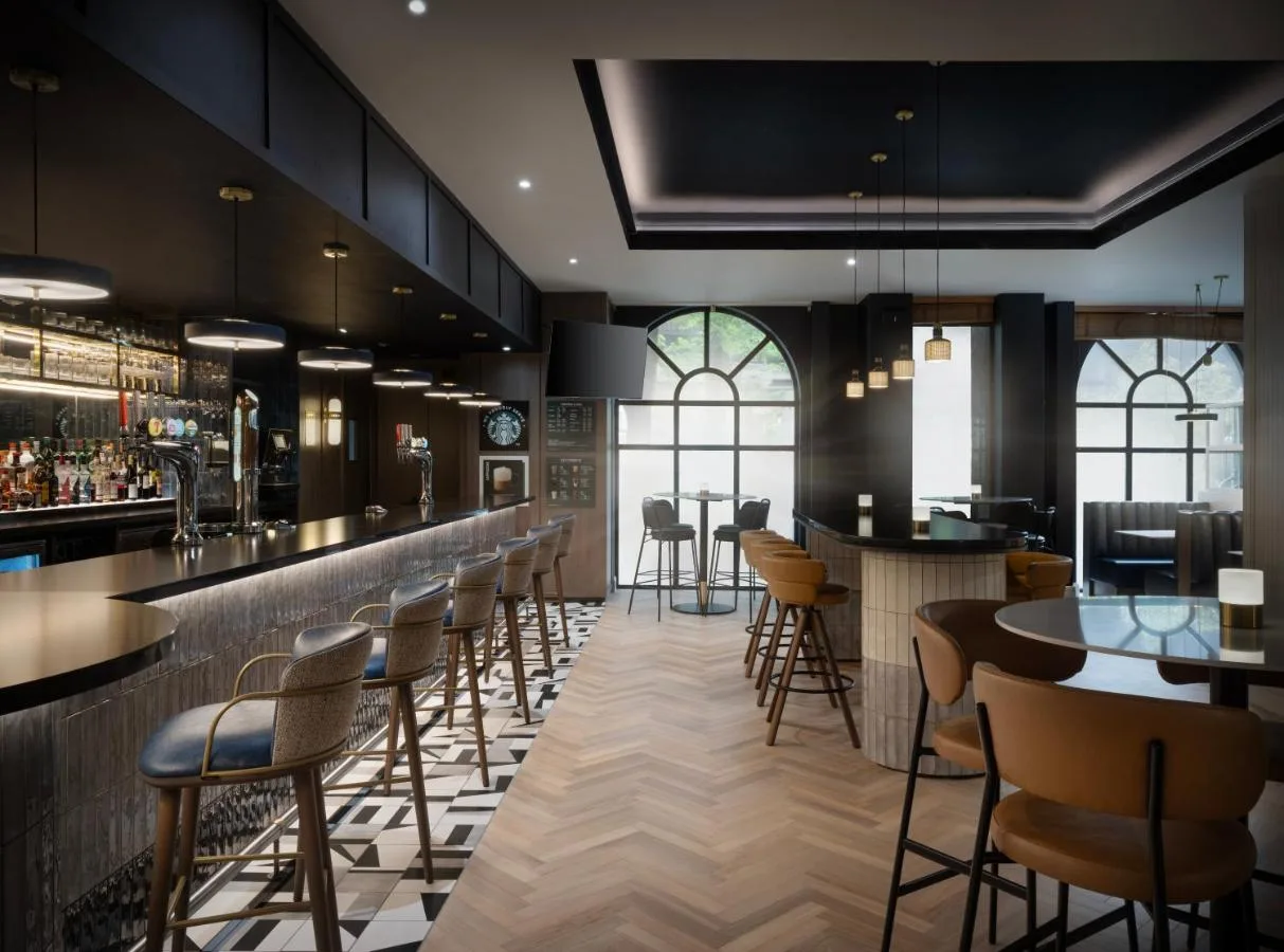 a bar in a restaurant with chairs and tables at Glasgow Marriott Hotel in Glasgow