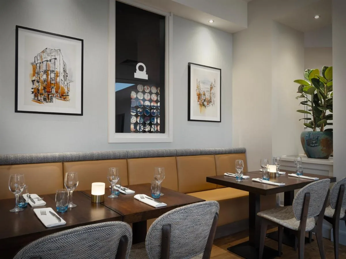 a dining room with two tables and chairs at Glasgow Marriott Hotel in Glasgow